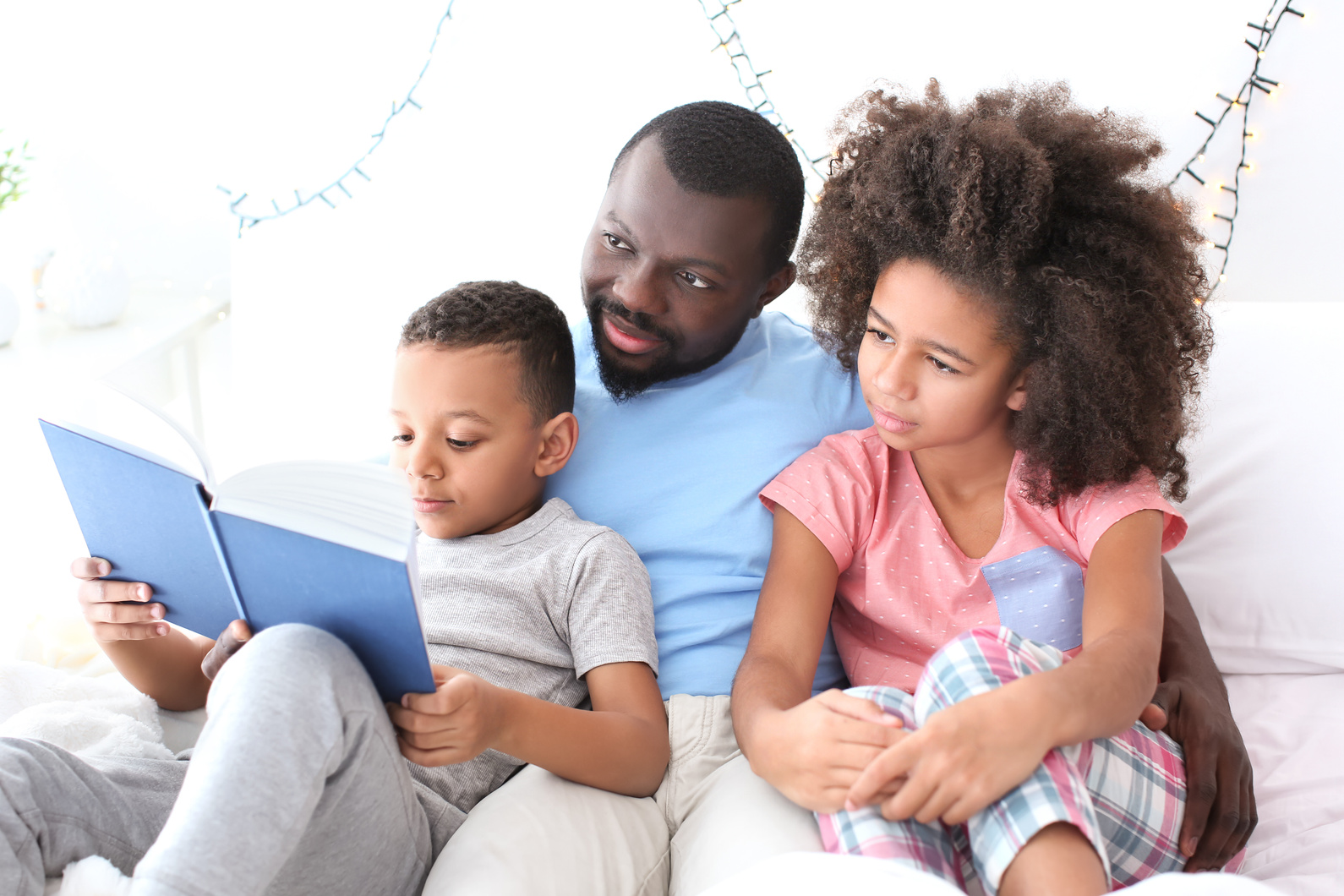 Father Reading Bedtime Story to His Children at Home